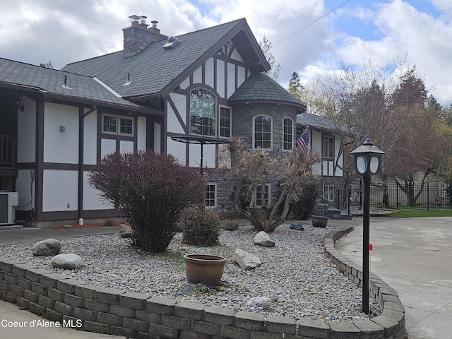 11268 N Friar Dr, Hayden, ID 83835 - exterior space with a chimney, central AC unit, fence, stucco siding, and stone siding