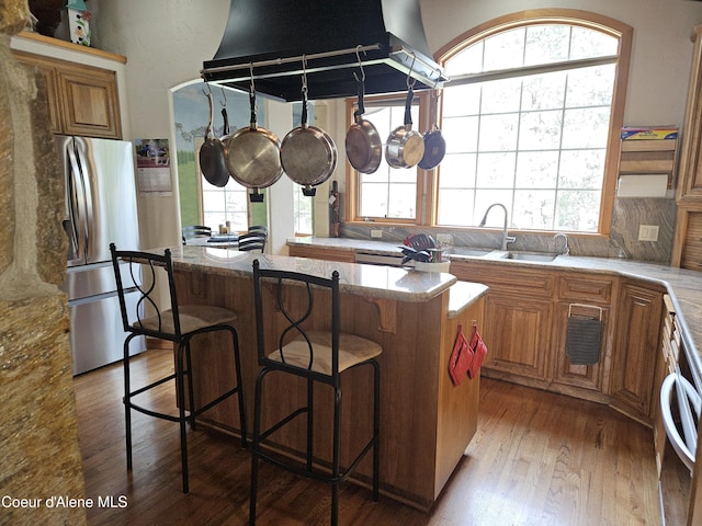 11268 N Friar Dr, Hayden, ID 83835 - kitchen featuring a sink, freestanding refrigerator, hardwood / wood-style flooring, under cabinet range hood, and a kitchen island