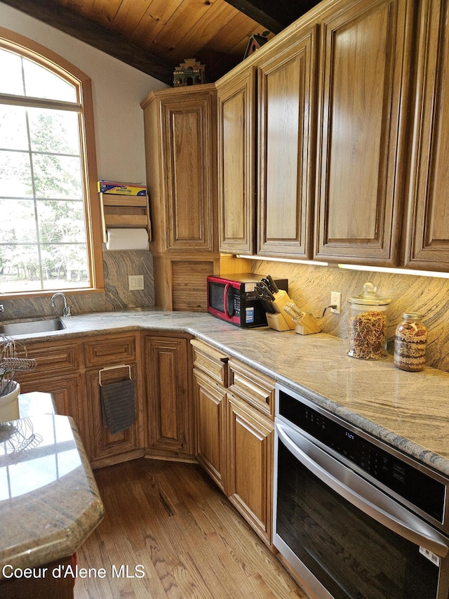 11268 N Friar Dr, Hayden, ID 83835 - kitchen featuring wood ceiling, brown cabinets, oven, and light wood-style floors