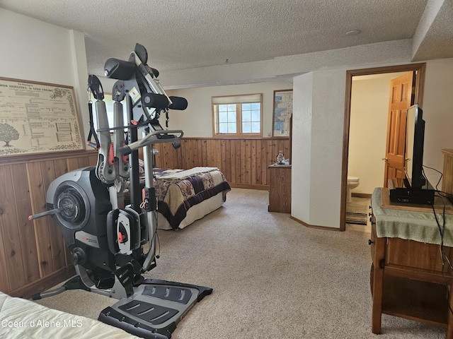 11268 N Friar Dr, Hayden, ID 83835 - carpeted bedroom with wainscoting, ensuite bathroom, wood walls, and a textured ceiling