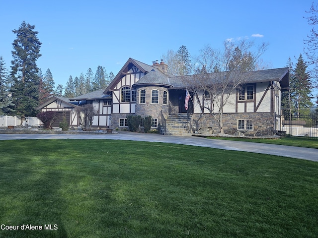 11268 N Friar Dr, Hayden, ID 83835 - tudor home featuring stucco siding, a front lawn, fence, and stone siding