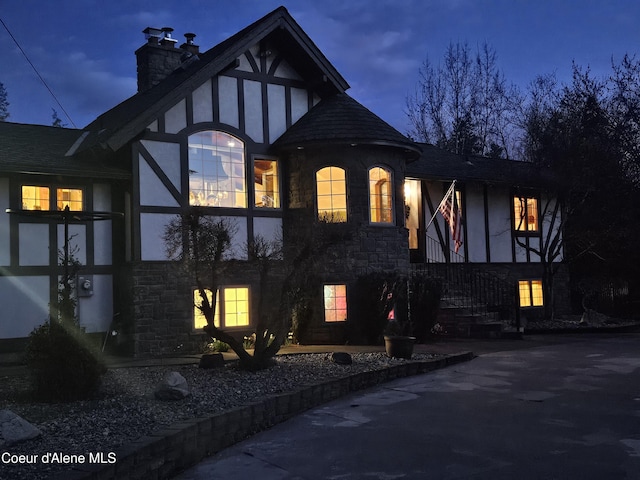 11268 N Friar Dr, Hayden, ID 83835 - view of side of home with stone siding, a chimney, and stucco siding
