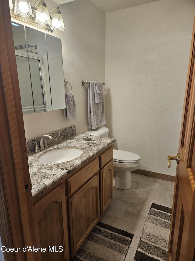 11268 N Friar Dr, Hayden, ID 83835 - bathroom with baseboards, toilet, and vanity