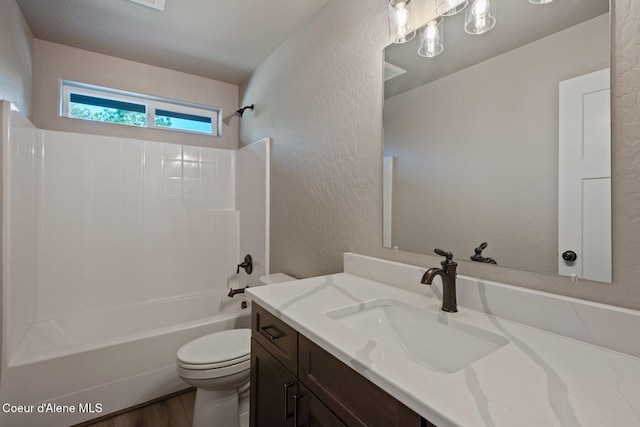 818 Sawbuck Rd, Spirit Lake, ID 83869 - bathroom with toilet, a textured wall, tub / shower combination, vanity, and wood finished floors