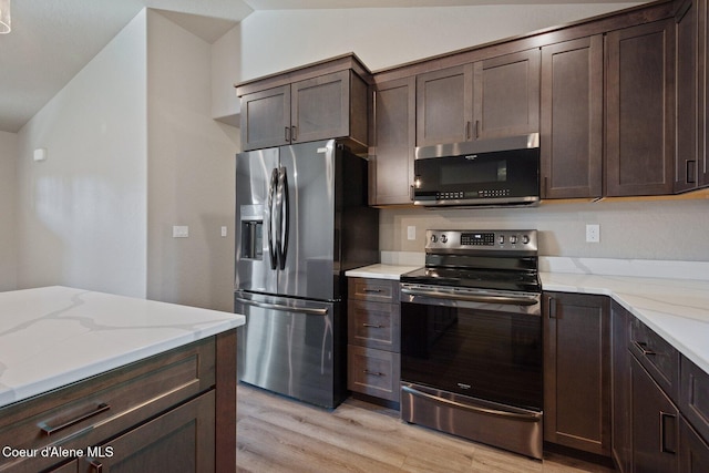 818 Sawbuck Rd, Spirit Lake, ID 83869 - kitchen featuring appliances with stainless steel finishes, light wood-type flooring, dark brown cabinets, and vaulted ceiling