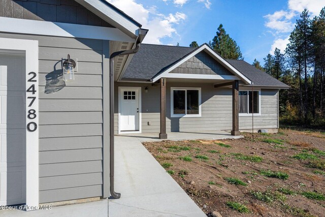 818 Sawbuck Rd, Spirit Lake, ID 83869 - doorway to property with roof with shingles