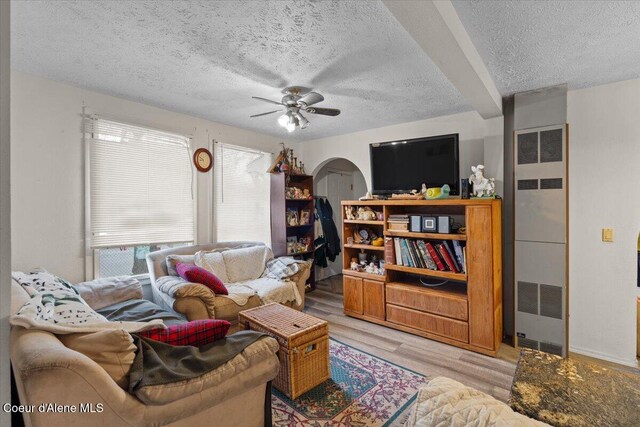 1515 E Elm Ave, Coeur Dalene, ID 83814 - living area with light wood finished floors, a heating unit, a textured ceiling, arched walkways, and ceiling fan