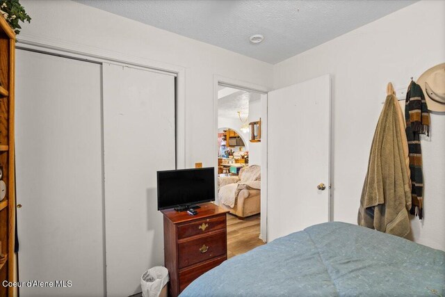 1515 E Elm Ave, Coeur Dalene, ID 83814 - bedroom featuring wood finished floors, a closet, and a textured ceiling