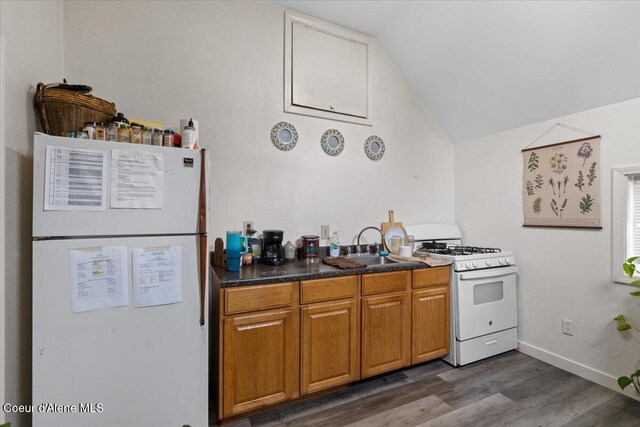 1515 E Elm Ave, Coeur Dalene, ID 83814 - kitchen with white appliances, lofted ceiling, dark wood-style flooring, dark countertops, and brown cabinetry