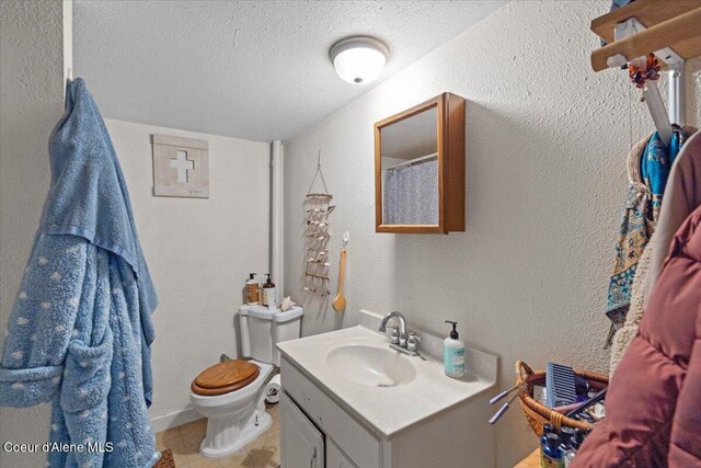 1515 E Elm Ave, Coeur Dalene, ID 83814 - bathroom featuring vanity, toilet, a textured ceiling, tile patterned floors, and a textured wall