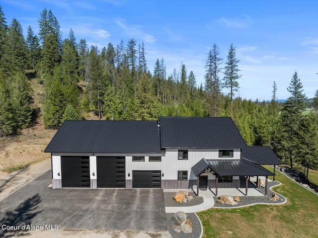 329 N Healing Dr, Blanchard, ID 83804 - view of front of house featuring a front lawn, driveway, a wooded view, and metal roof