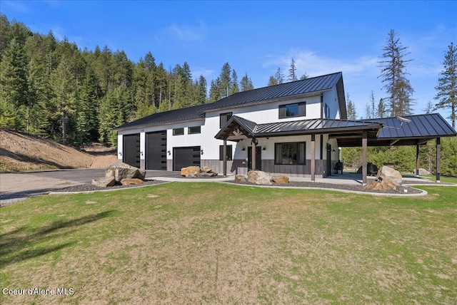 329 N Healing Dr, Blanchard, ID 83804 - rear view of property featuring a lawn, aphalt driveway, covered porch, metal roof, and a standing seam roof