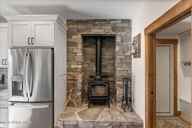 329 N Healing Dr, Blanchard, ID 83804 - kitchen featuring white cabinets, stainless steel fridge, and a wood stove