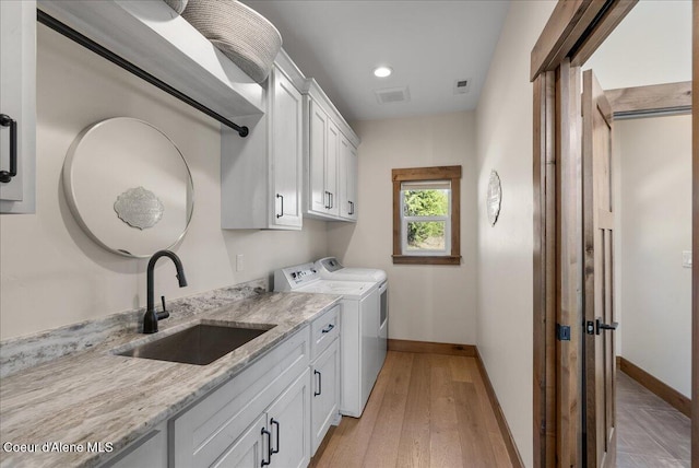 329 N Healing Dr, Blanchard, ID 83804 - clothes washing area featuring visible vents, a sink, baseboards, washer and dryer, and cabinet space
