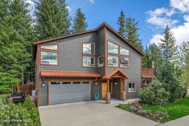 contemporary home with an attached garage, driveway, a standing seam roof, and metal roof