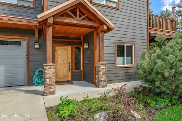 doorway to property with a garage and covered porch