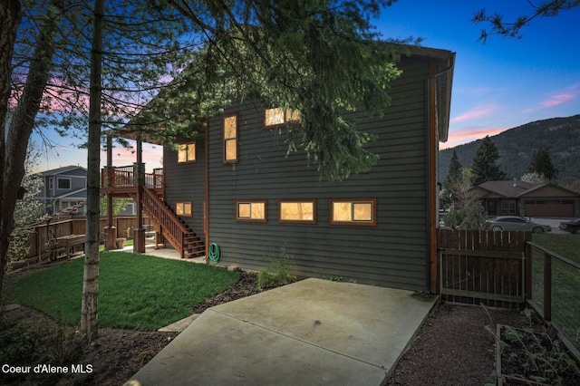 rear view of property with a lawn, fence, stairs, and a patio