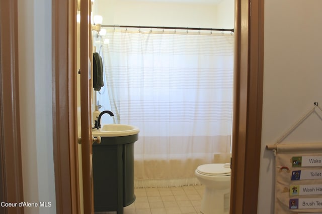 bathroom with tile patterned floors, curtained shower, toilet, and a sink