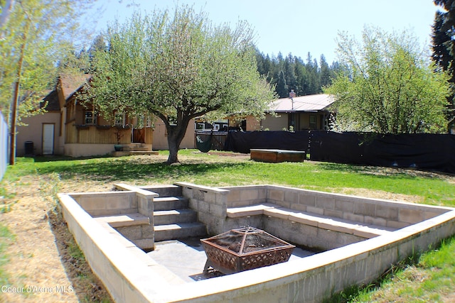 view of yard with a fire pit and fence