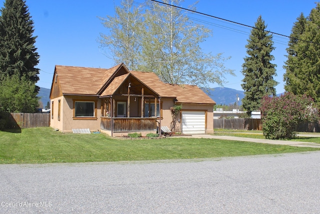 view of front facade with stucco siding, driveway, fence, and a garage