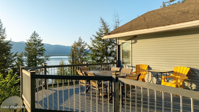 3338 Bottle Bay Rd, Sagle, ID 83860 - wooden deck with outdoor dining area and a water and mountain view