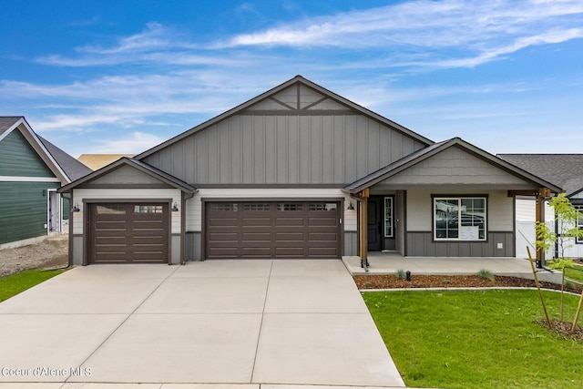 view of front facade with an attached garage, board and batten siding, driveway, a porch, and a front yard
