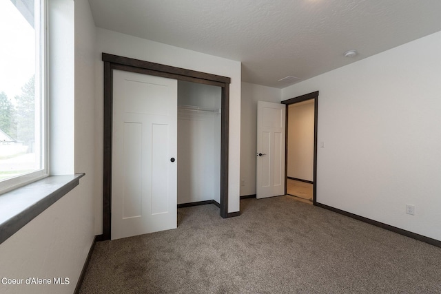 unfurnished bedroom featuring baseboards, a closet, and light colored carpet