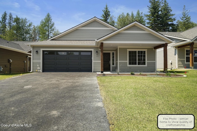 view of front of property featuring driveway, a porch, a front yard, and a garage