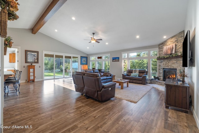 5867 W Sparrowhawk Dr, Rathdrum, ID 83858 - living area with wood finished floors, a healthy amount of sunlight, a ceiling fan, vaulted ceiling with beams, and a fireplace