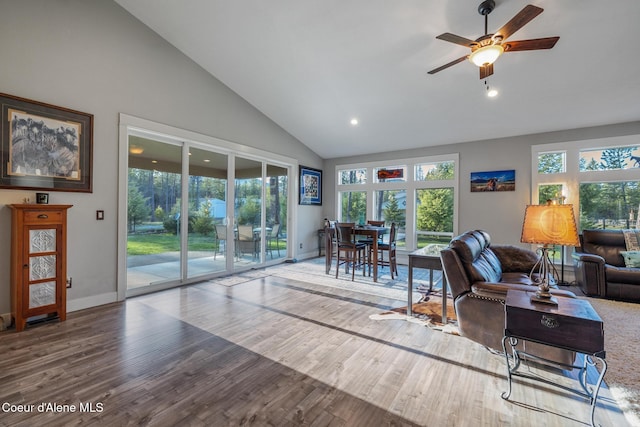 5867 W Sparrowhawk Dr, Rathdrum, ID 83858 - living area with wood finished floors, a healthy amount of sunlight, a ceiling fan, and high vaulted ceiling
