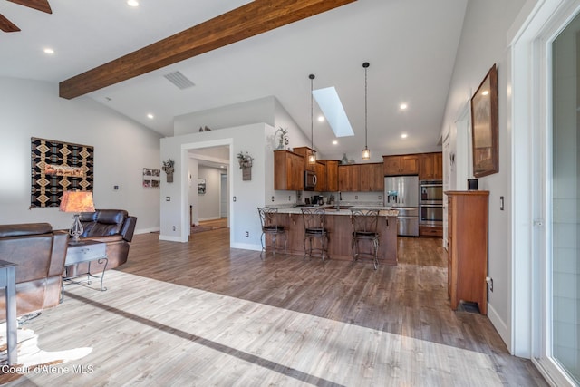 5867 W Sparrowhawk Dr, Rathdrum, ID 83858 - kitchen with a kitchen breakfast bar, a peninsula, vaulted ceiling with skylight, appliances with stainless steel finishes, and open floor plan