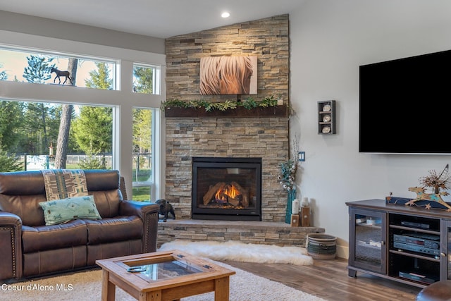 5867 W Sparrowhawk Dr, Rathdrum, ID 83858 - living room featuring recessed lighting, a stone fireplace, high vaulted ceiling, and wood finished floors