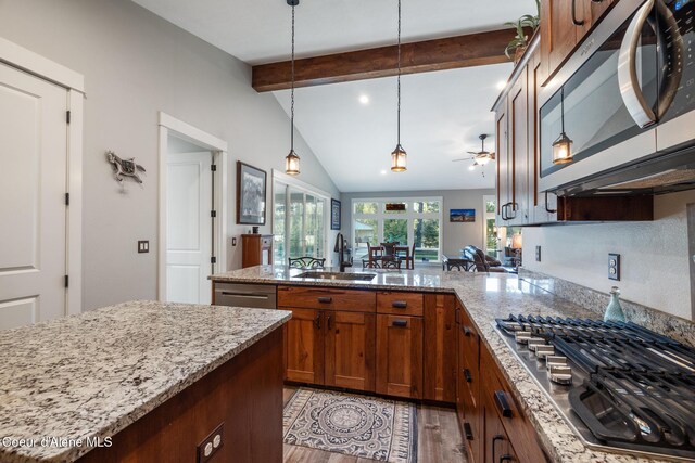 5867 W Sparrowhawk Dr, Rathdrum, ID 83858 - kitchen featuring lofted ceiling with beams, a peninsula, a sink, light wood-style floors, and appliances with stainless steel finishes