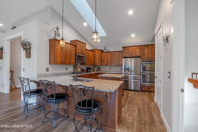 5867 W Sparrowhawk Dr, Rathdrum, ID 83858 - kitchen featuring a sink, brown cabinetry, a peninsula, appliances with stainless steel finishes, and recessed lighting
