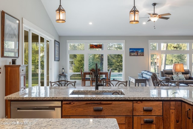 5867 W Sparrowhawk Dr, Rathdrum, ID 83858 - kitchen featuring brown cabinets, lofted ceiling, and light stone counters