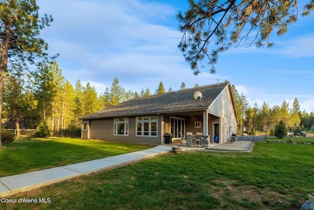 5867 W Sparrowhawk Dr, Rathdrum, ID 83858 - rear view of property featuring a lawn, a patio, and fence