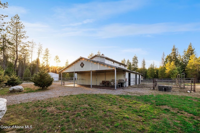 5867 W Sparrowhawk Dr, Rathdrum, ID 83858 - back of house featuring a carport, gravel driveway, and an exterior structure