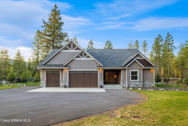5867 W Sparrowhawk Dr, Rathdrum, ID 83858 - craftsman-style home with a front lawn, aphalt driveway, stone siding, board and batten siding, and fence