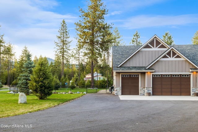5867 W Sparrowhawk Dr, Rathdrum, ID 83858 - view of front facade with a front lawn, stone siding, board and batten siding, a shingled roof, and fence