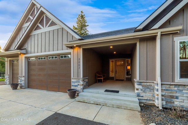 5867 W Sparrowhawk Dr, Rathdrum, ID 83858 - property entrance featuring a garage, stone siding, concrete driveway, and board and batten siding