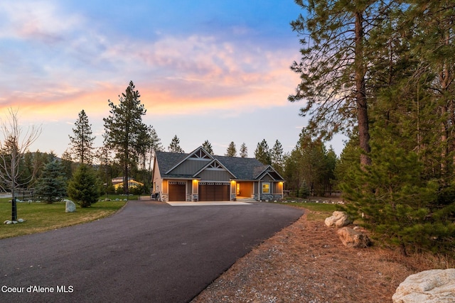 5867 W Sparrowhawk Dr, Rathdrum, ID 83858 - view of front facade with an attached garage, stone siding, and driveway