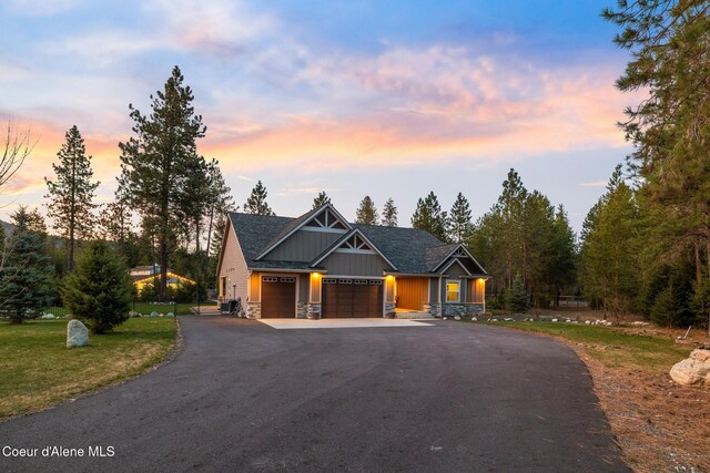 5867 W Sparrowhawk Dr, Rathdrum, ID 83858 - craftsman-style house with aphalt driveway, stone siding, board and batten siding, a garage, and roof with shingles