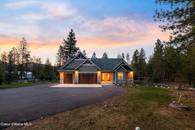 5867 W Sparrowhawk Dr, Rathdrum, ID 83858 - view of front of home featuring driveway, stone siding, board and batten siding, an attached garage, and a yard