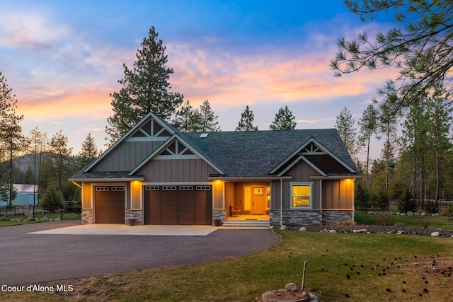 5867 W Sparrowhawk Dr, Rathdrum, ID 83858 - craftsman inspired home with aphalt driveway, board and batten siding, stone siding, a front yard, and a garage