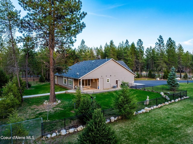 5867 W Sparrowhawk Dr, Rathdrum, ID 83858 - back of property featuring a shingled roof, a fenced backyard, and a yard