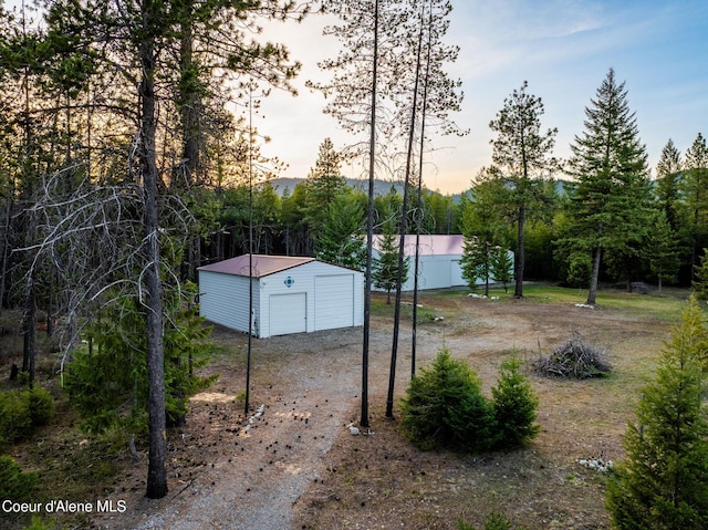 5867 W Sparrowhawk Dr, Rathdrum, ID 83858 - view of yard with an outdoor structure, driveway, a shed, and a garage