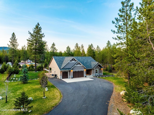 5867 W Sparrowhawk Dr, Rathdrum, ID 83858 - view of front of home with a garage, driveway, board and batten siding, a shingled roof, and a front yard