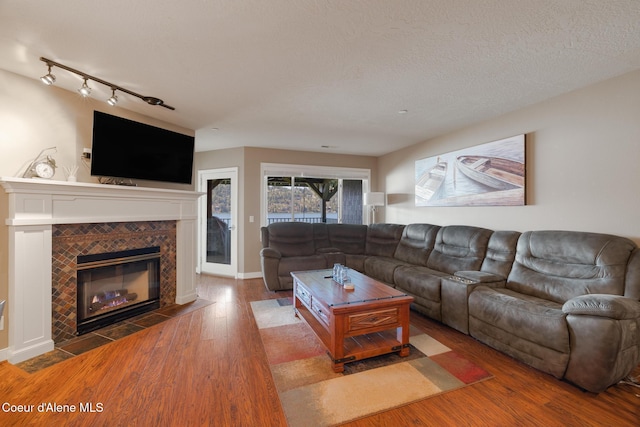 4549 S Arrow Point Dr # 207, Harrison, ID 83833 - living room featuring a fireplace, wood finished floors, and rail lighting