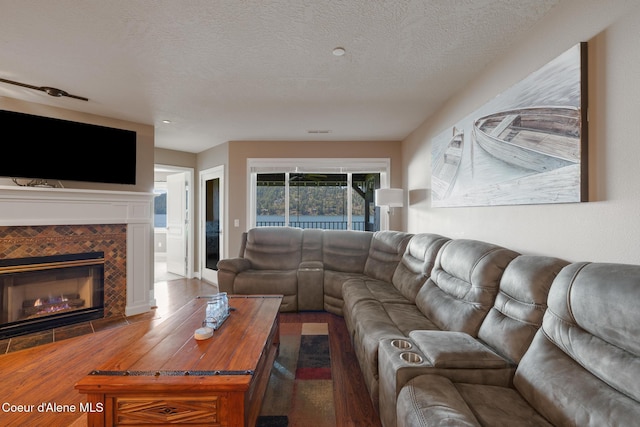 4549 S Arrow Point Dr # 207, Harrison, ID 83833 - living area with a tile fireplace, a textured ceiling, and wood finished floors