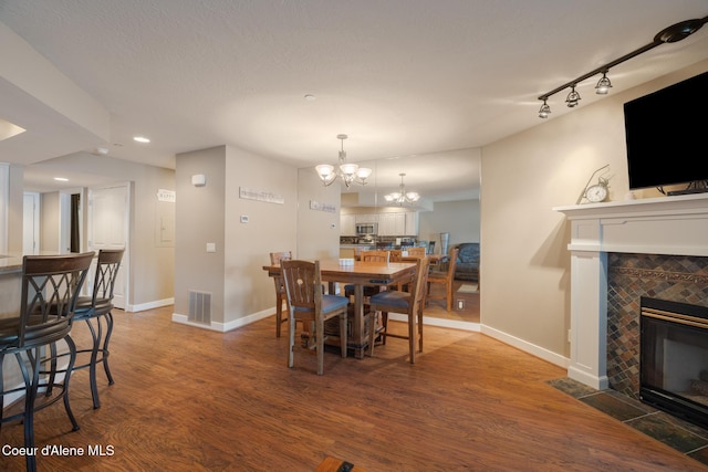 4549 S Arrow Point Dr # 207, Harrison, ID 83833 - dining space with baseboards, a tiled fireplace, visible vents, and an inviting chandelier
